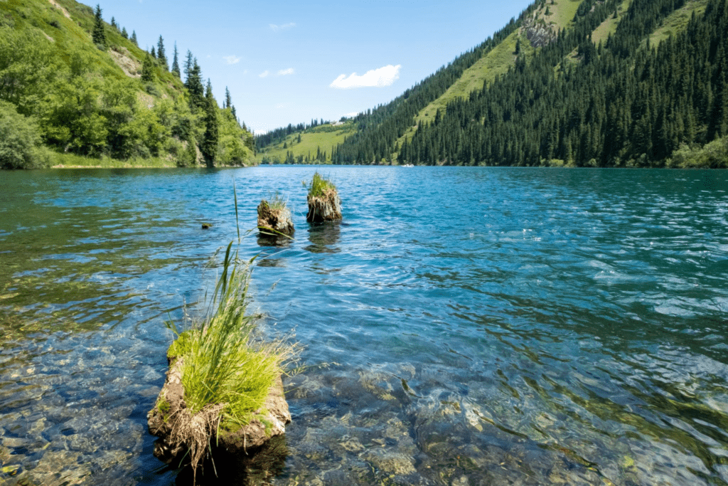 Beautiful view to Kolsai or Saty lake with mountains background. Summer vacation concept.